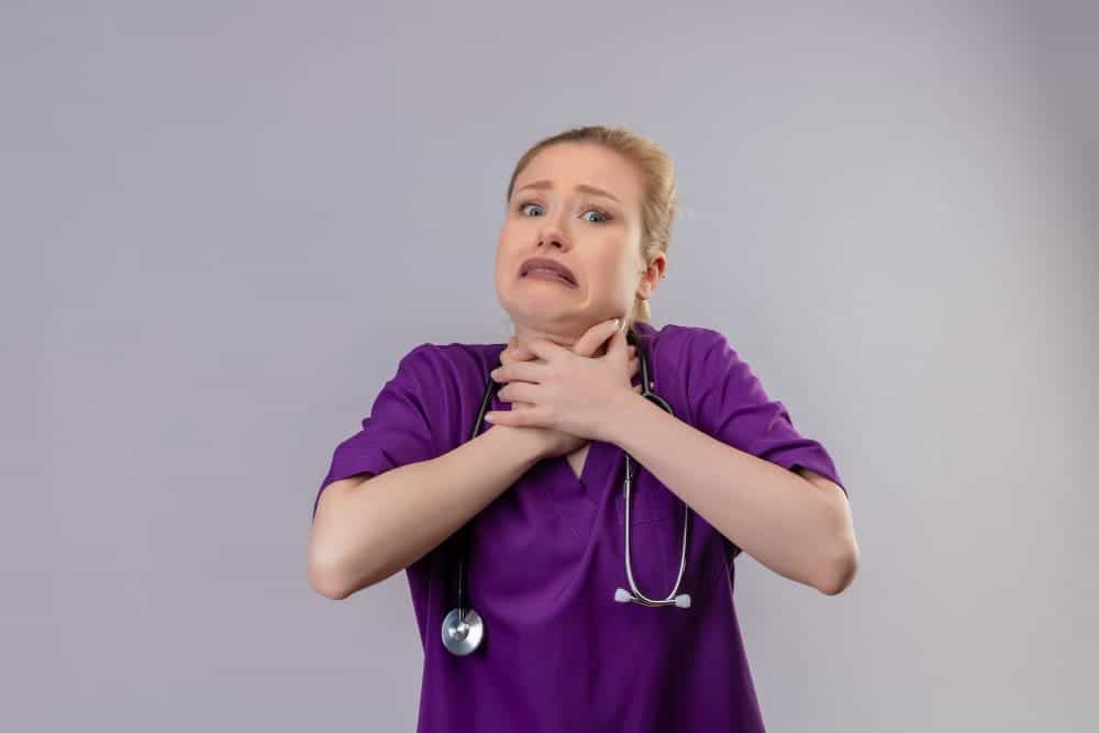 Sudden sore throat and difficulty breathing in a healthcare professional.